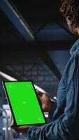 Vertical Data center engineers monitoring neural network LLM visualization using green screen tablet. Server farm IT experts oversee rigs powering machine learning processes using chroma key device, camera A video