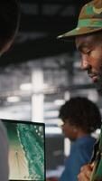 Vertical Military IT specialists in server hub using laptop scanner tools to oversee battlefield during warfare. Army data center admins doing transmission analysis and live UAV system monitoring, camera B video