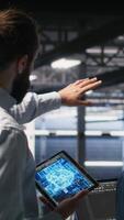 Vertical Software developers in data center monitoring AI LLM visualization. Server farm teamworking colleagues doing brainstorming, overseeing rigs powering machine learning processes, camera B video
