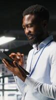 Vertical Software developers on data center industrial platform analyzing performance outputs on devices. Server room IT specialists collaborating on finetuning mainframes configurations, camera B video
