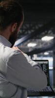 Vertical Military units overseeing AI computing operations on notebook in high tech server facility. Army tech experts using machine learning intelligence to oversee communication systems video