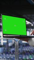 Vertical Close up of server room worker using green screen laptop next to colleague reviewing AI LLM visualization. Data center IT professional chroma key notebook to monitor AI systems, camera A video