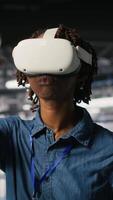 Vertical Data center programmer using virtual reality technology to simulate artificial intelligence neural networks. Woman in server farm using VR headset equipment to oversee AI systems, camera B video