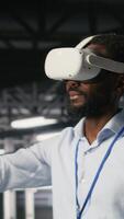 Vertical Data center admin using VR headset to monitor neural network AI systems. Server room employee using virtual reality tech to oversee equipment powering machine learning processes, camera B video