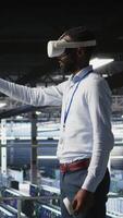 Vertical Engineer using VR headset in data center to update server tech, configuring equipment using software tools. Server hub employee reviewing hardware analytics using virtual reality, camera A video