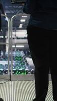 Vertical Data center manager overseeing work done by admin using neural network AI LLM visualization. Server farm team leader and worker overseeing rigs powering machine learning processes, camera A video