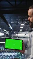 Vertical Military technicians in data center use green screen mockup tablet to monitor systems. Army operators in server room ensuring stable infrastructure using chroma key device, camera A video