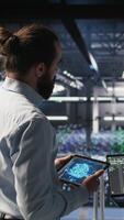 Vertical Data center system administrators performing maintenance on supercomputers used for AI. Engineering team managing server hub rigs used for deep learning training, camera A video