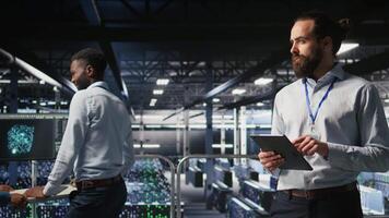 Server room technician next to coworkers reviewing neural network code and LLM visualization dashboards. Data center IT specialist next to colleagues monitoring AI system performance, camera A video