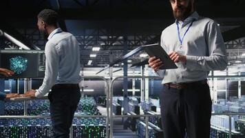 Portrait of smiling engineer in data center monitoring neural network LLM visualization. Cheerful server hub IT specialists overseeing rigs powering machine learning processes, camera A video