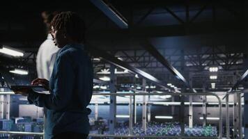 Data center engineer walking on industrial platform, running diagnostics on equipment to identify errors. Server farm IT professionals preventing rigs failure to minimize downtime, camera A video