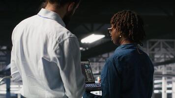 Data center manager overseeing work done by admin using neural network AI LLM visualization. Server farm team leader and worker overseeing rigs powering machine learning processes, camera B video