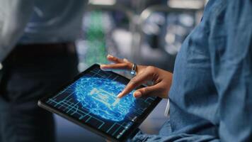 Close up of server farm admin using tablet to do infrastructure AI machine learning automatization. Data center software developer doing maintenance using artificial intelligence, camera B video