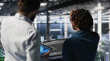 Server farm manager overseeing workers doing infrastructure AI machine learning automatization. Data center team leader supervising employees using artificial intelligence, camera B video