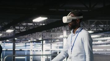 Engineer using VR headset in data center to update server tech, configuring equipment using software tools. Server hub employee reviewing hardware analytics using virtual reality, camera B video