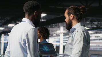Server farm coworkers doing infrastructure AI machine learning automatization. Data center computer scientists collaborating to maintain servers using artificial intelligence, camera B video