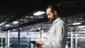 Data center computer scientists using devices to review AI LLM visualizations. Server hub engineering team working to analyze neural networks outputs, ensuring stable gear operations video