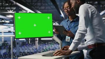 Server hub colleagues doing brainstorming, using chroma key device to review diagnostics. Employees doing maintenance tasks in data center, looking at green screen display video