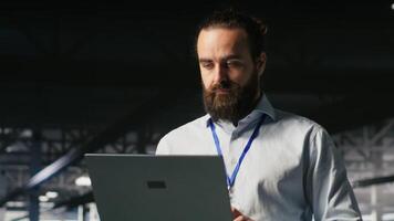 Programmer on data center platform using laptop to monitor neural network LLM visualization. Industrial server farm IT professional overseeing rigs powering machine learning processes video