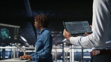 Close up of data center programmer looking at code debugging tools running on tablet. Server farm IT professional checking machine learning script automating tasks, camera A video