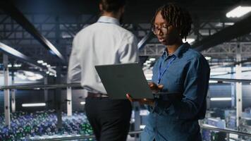 Data center engineer walking on industrial platform, running diagnostics on equipment to identify errors. Server farm IT professionals preventing rigs failure to minimize downtime, camera B video