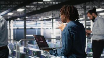 Worried workers trying to fix hacked infrastructure systems. Panicked engineers in data center react to ransomware warning on laptop screen, scrambling to launch emergency response protocol, camera B video