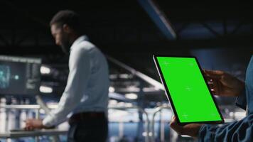 Close up of server hub admin using isolated screen tablet next to colleague reviewing AI LLM visualization. Data center employee using mockup device to monitor machine learning systems, camera A video