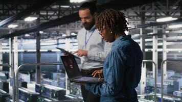 Data center software developer panicking after receiving critical error popup on laptop display. African american woman in server hub alerted by bugs causing low hardware performance, camera B video