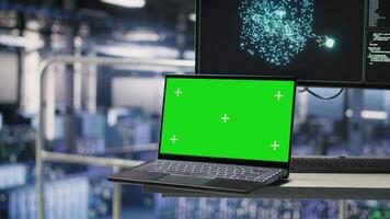 Mockup notebook in data center displaying neural network activity. Automated infrastructure green screen laptop workstation on industrial platform inside server hub showing AI machine learning scripts video