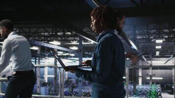Data scientist in server farm reviewing neural network code and LLM visualization dashboards. IT expert walking on data center industrial platform, monitoring AI system performance, camera A video