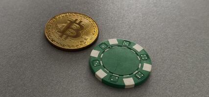 Bitcoin gold coin with poker chips on a green poker table against black background. Blockchain casino. Online gambling. photo