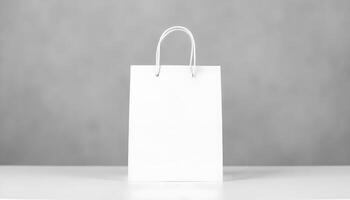 A pristine white paper shopping bag with elegant handles sits on a smooth, white surface. photo