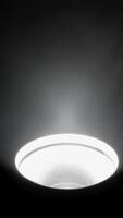 Ceiling light fixture illuminating in a dark room, Close-up of a ceiling light emitting bright rays in a dark space. video