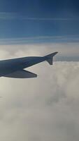 Airplane Wing Above Clouds in Clear Sky, Close-up of an airplane wing flying above dense white clouds under a bright blue sky video