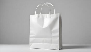 An isolated blank white shopping bag sits on a table, perfect for branding and marketing. photo