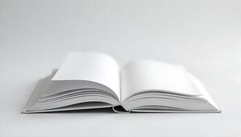 A studio shot shows an open book with blank pages, set against a clean white background. photo