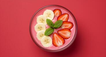 A colorful and healthy smoothie bowl, with fresh strawberries, bananas, and mint. photo