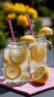 Two mason jars with lemon slices and straws photo