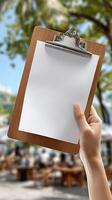A person holding a clipboard with a blank paper on it photo