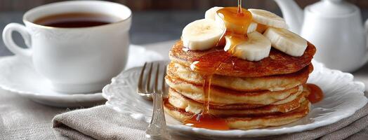 A stack of pancakes with bananas and syrup photo