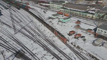 Winter railway operations in a snowy yard with multiple train tracks video