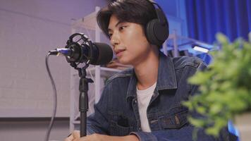 Side view of content creator recording livestream with microphone in home studio video