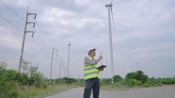 Low angle and wide shot of engineer working at wind turbine field. video