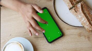 Hand using smartphone at cafe with bread and coffee video