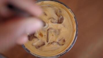 Ice coffee preparation with creamy swirl and ice cubes video
