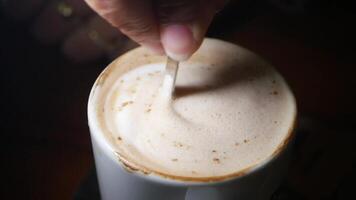 Enjoying a warm cup of frothy coffee in a cozy setting video