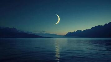 The moon is seen over the water in front of mountains photo