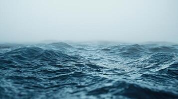 Waves move steadily, creating a rhythmic sound as they wash against the shore. The fog envelops the scene, adding a mysterious atmosphere to the tranquil morning photo