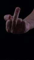 Hand gesture of defiance is captured in a dark environment showcasing anger and frustration video