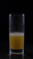 man's hand reaching for a cold glass of freshly squeezed orange juice in a dimly lit setting video